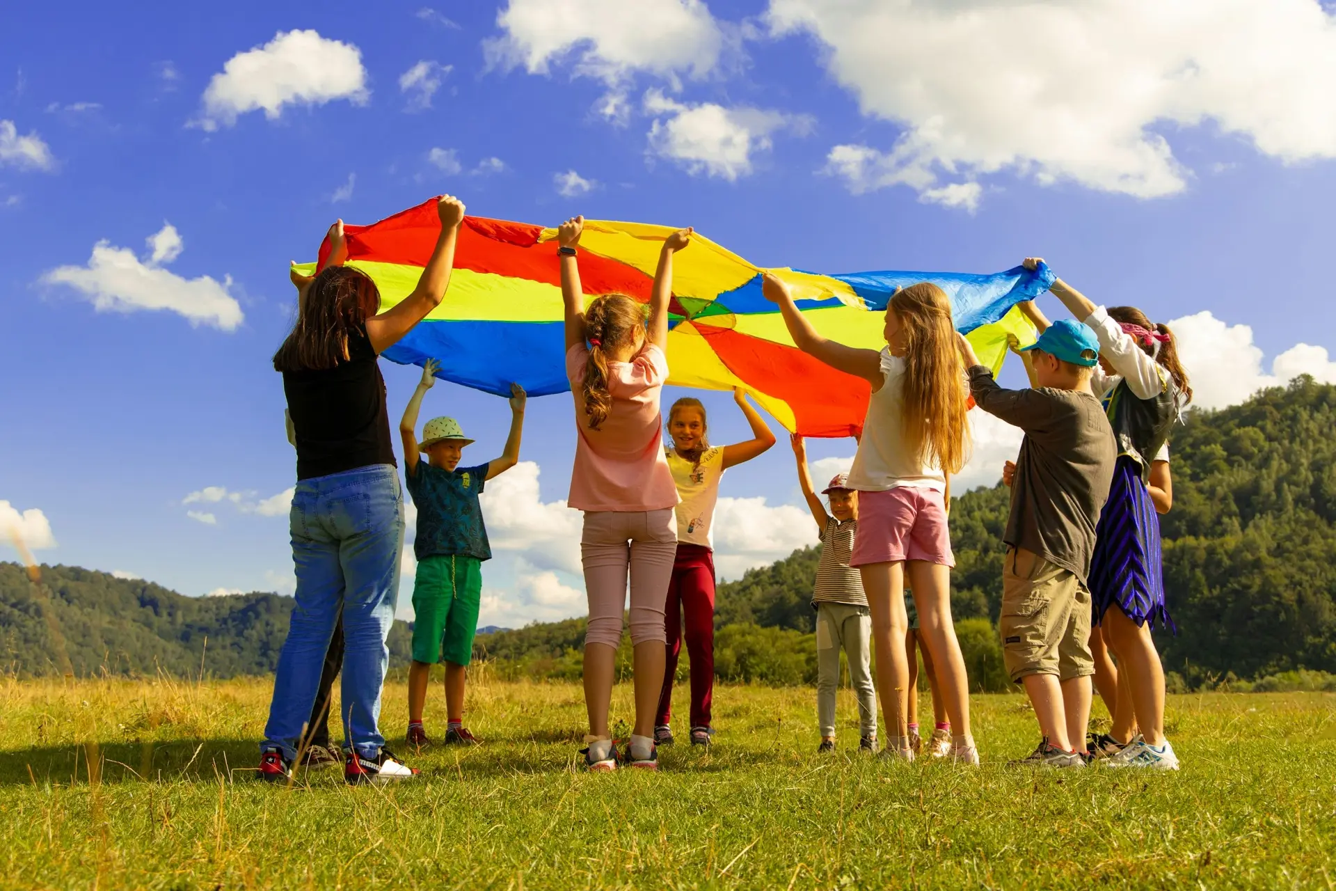 Kinderen spelen met een kleurrijk parachutedoek